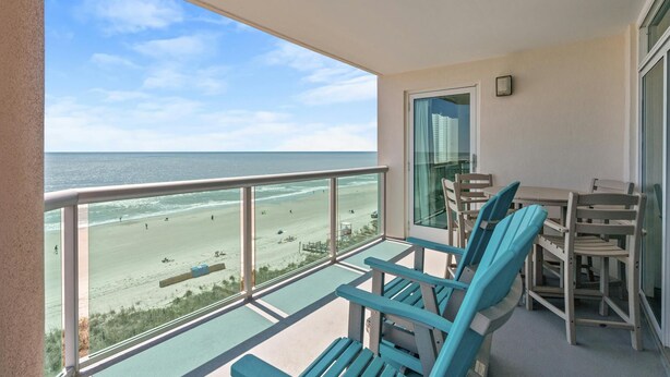Un balcon avec vue sur la plage et l’océan.