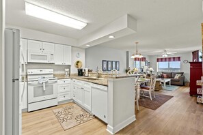Enjoy cooking in the kitchen with a central island, sink, and ample counter space, complemented by a dining area and cozy living room.
