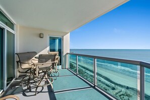 A balcony with a view of the ocean, a door, and two chairs. - This is a fantastic corner condo unit in Laguna Keyes facing the ocean | Laguna Keyes -  911 (North Myrtle Beach)