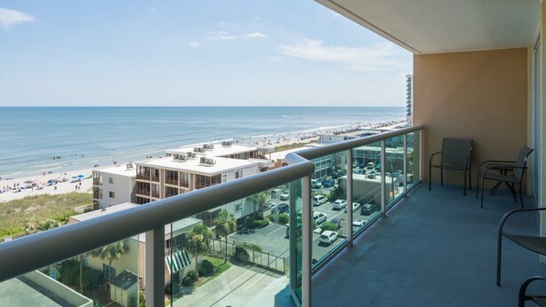 Een balkon met uitzicht op het strand en de oceaan.