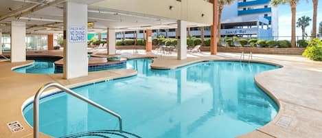 A pool area with multiple pools, a sign indicating shallow water no diving allowed, and a building labeled "San-A-Bel" in the background.