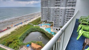 A high-rise hotel with a view of the beach and a swimming pool.