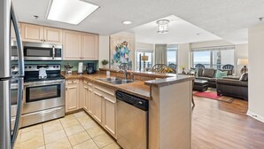 Een moderne keuken met roestvrijstalen apparatuur, een centraal eiland en een eetgedeelte met uitzicht.