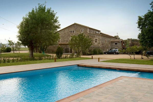A stone building with a swimming pool in front. - Mas La Casassa (Sant Gregori)