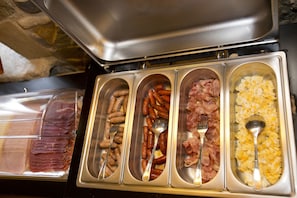 A buffet with various food options including sausages, ham, and scrambled eggs. - Mas La Casassa (Sant Gregori)