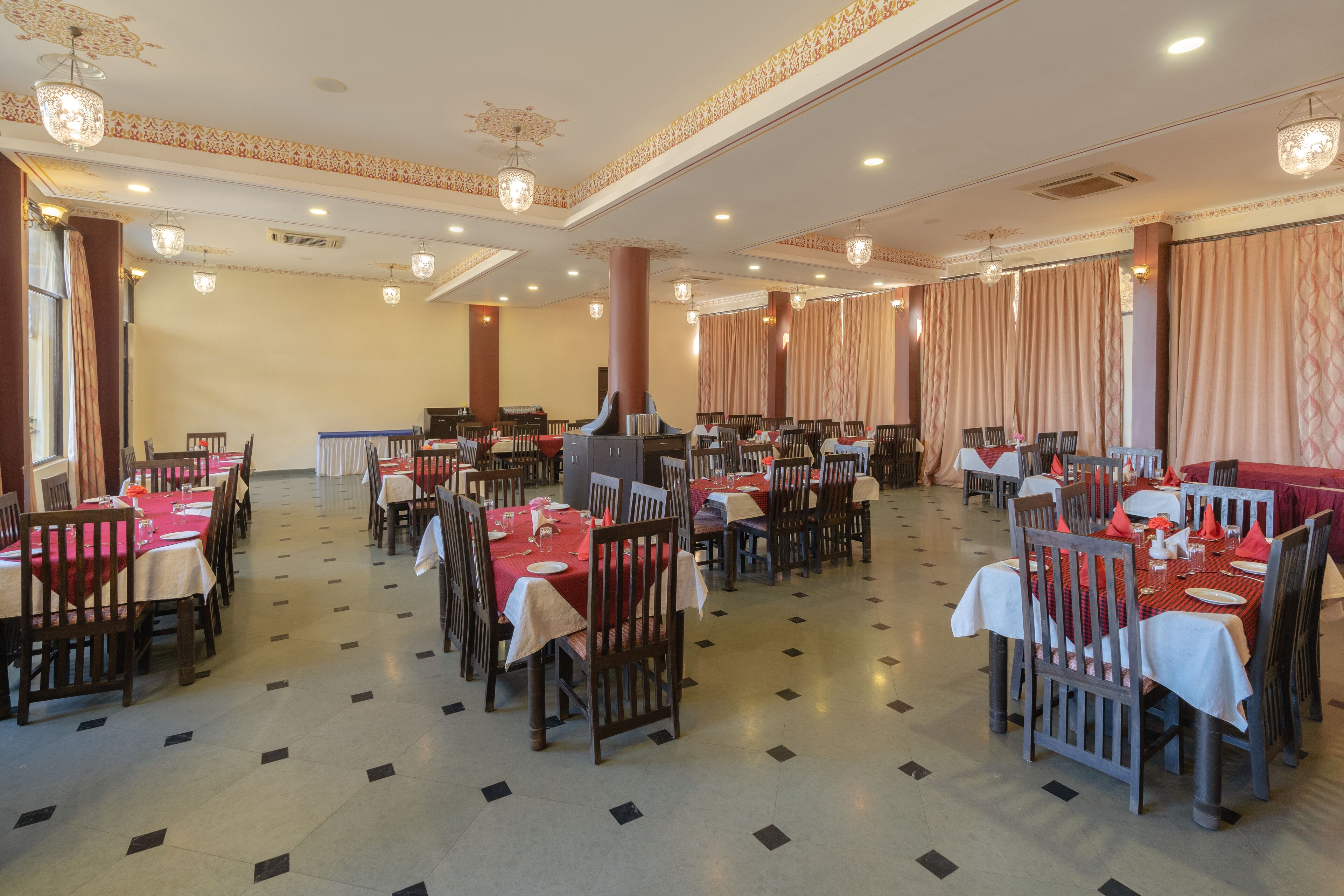 Un comedor amplio con varias mesas y sillas, dispuesto en una distribución simétrica.