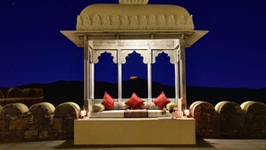 A traditional Indian pavilion with a white, ornate structure and a view of the night sky. - The Kumbha Bagh (Kumbhalgarh)