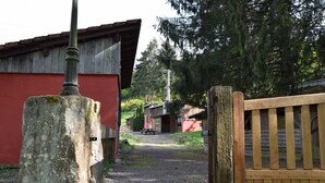 Un bâtiment rustique en bois, à l’extérieur peint en rouge, avec un chemin de gravier menant à l’entrée.