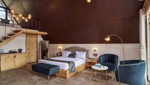 A modern bedroom with a wooden bed, a nightstand, a desk, and two chairs. - Serendipity Lakes and Resorts (Tamia)