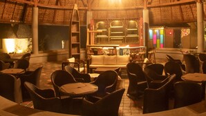 An indoor seating area with wicker furniture and a thatched roof. - Serendipity Lakes and Resorts (Tamia)