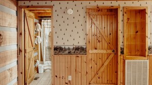 A wooden interior with a wooden door, a towel rack, and a wall with a mountain scene. - Gettin' Lucky: Hit the Jackpot in the Smokies (Pigeon Forge)