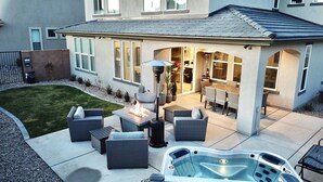 A patio area with outdoor furniture, a fire pit, and a hot tub. - Desert Living 5 Bedroom Home by RedAwning (Washington)