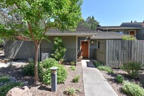 A residential house with a front yard, a wooden fence, and a pathway leading to the entrance. - 824 Oak Creek At Silverado 3 Bedroom Condo by RedAwning (Napa)