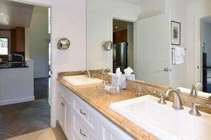 A bathroom with two sinks, a large mirror, and a countertop with a towel dispenser. - 824 Oak Creek At Silverado 3 Bedroom Condo by RedAwning (Napa)