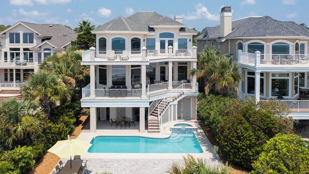 A multi-story house with a swimming pool, outdoor seating, and a well-maintained garden. - 81 Dune Lane - Oceanfront 6BR | Private Pool & Spa | Sleeps 18 (Hilton Head Island)