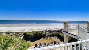 A beach view from a balcony with sun loungers and a staircase leading to a deck. - 81 Dune Lane - Oceanfront 6BR | Private Pool & Spa | Sleeps 18 (Hilton Head Island)