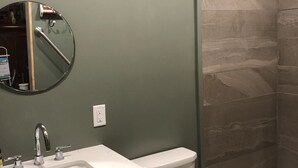 Un bagno con lavandino, specchio e WC.