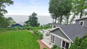 Une propriété résidentielle dotée d’une pelouse bien entretenue, d’un patio couvert et d’une vue sur la mer.
