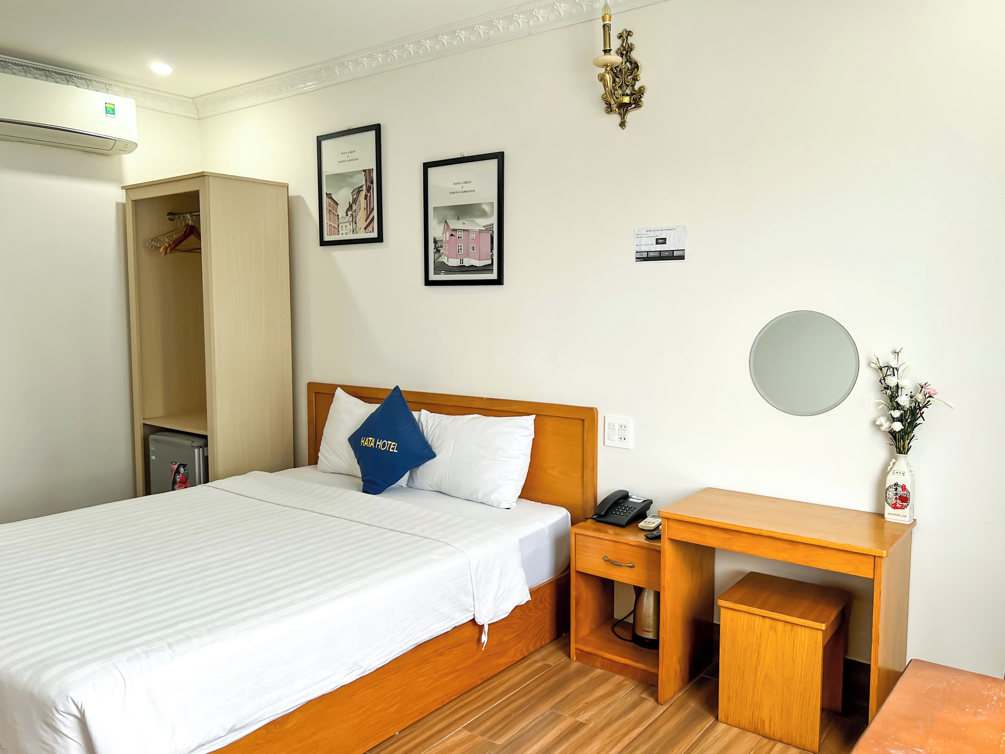 Ein Hotelzimmer mit Bett, Nachttisch, Schreibtisch, Kleiderschrank und Spiegel.