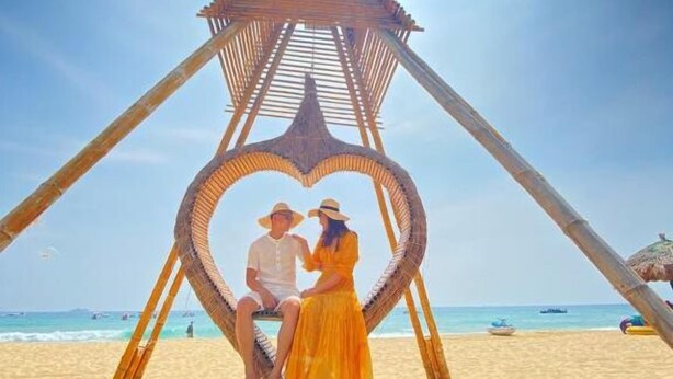 A beach scene with a wooden structure featuring a heart-shaped design. - Hata hotel (Quy Nhon Nam)