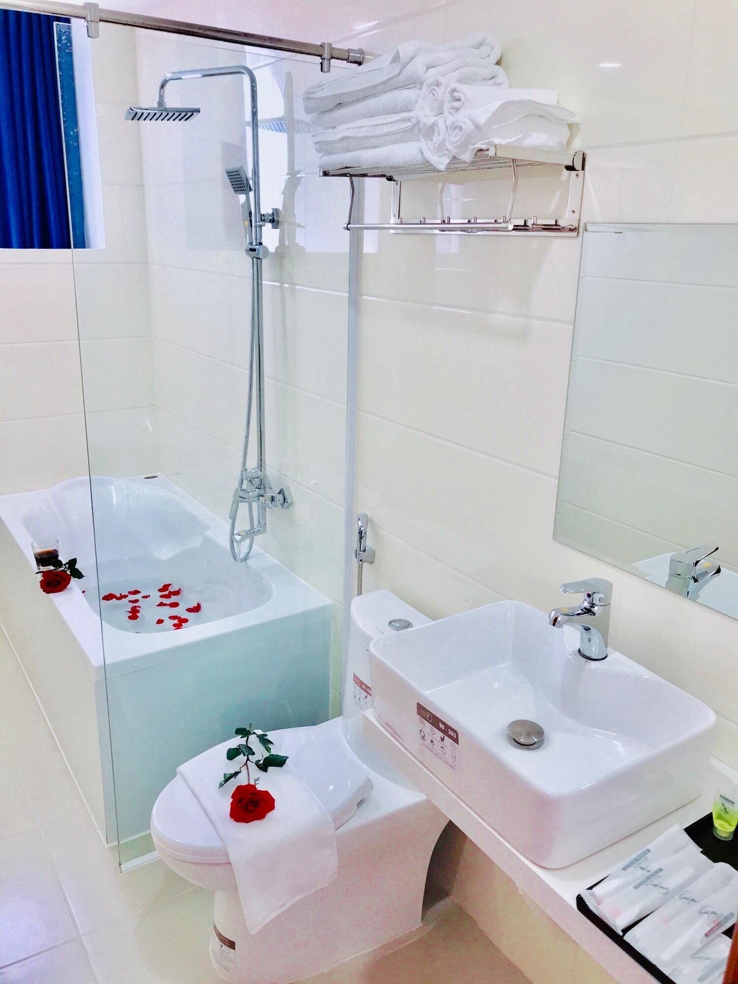 A modern bathroom with a glass-enclosed bathtub, a separate shower area, a toilet, and a sink.