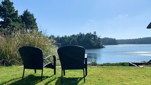 Dos sillas mirando un lago con una isla boscosa al fondo.
