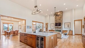 Una cocina amplia con una isla grande, armarios de madera y una chimenea de piedra.
