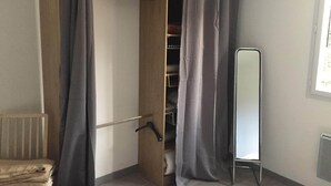 A walk-in closet with grey curtains, a full-length mirror, and a radiator. - Gîte 4p Tout confort bord de cher, calme, Animaux ok, Zoo Beauval chenonceau (Bléré)