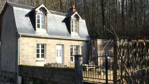 A two-story stone house with a gabled roof, a brick chimney, and a gated entrance. - Gîte 4p Tout confort bord de cher, calme, Animaux ok, Zoo Beauval chenonceau (Bléré)