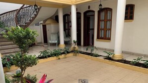 A spacious courtyard with a tiled floor, a staircase, and several potted plants. - OYO Hotel Real De Cortés (Xalapa)