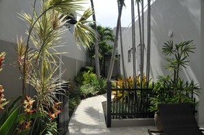 Escape to a serene oasis surrounded by lush tropical plants and a tranquil seating area.