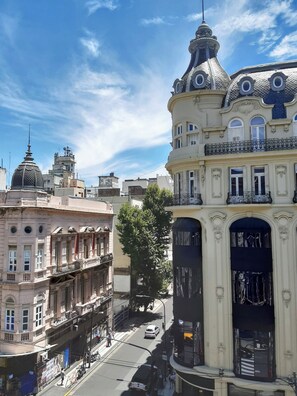 A street view with historic buildings, including a building with a dome and another with ornate balconies. - Hotel Chemin (Buenos Aires)