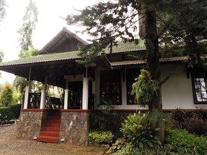 A building with a covered porch, stone steps, and a tiled roof. - OYO 604 Cemara S Homestay (Batu)