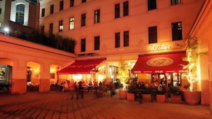 An outdoor dining area with multiple tables and chairs, surrounded by buildings with signage reading "Spiler." - Hotel Gozsdu Court Ex Gozsdu Court Apartment (Budapest)