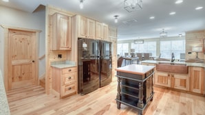 A spacious kitchen with wooden cabinets, a large refrigerator, and a dining area with a table and chairs.