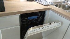 Una cucina compatta con lavastoviglie, lavello e piano di lavoro.