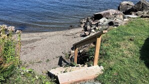 Una escalera de madera que desciende hacia una costa rocosa a orillas de un lago.