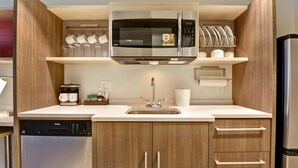 Una cucina moderna dotata di forno a microonde, macchina del caffè e lavastoviglie.