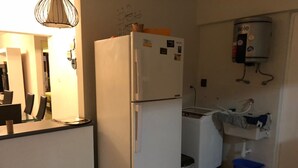 A compact kitchen with a refrigerator, a washing machine, and a water heater. - Santa Maria del Mar, Terramar 315, 204 (Urb Santa Maria del Mar)