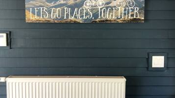 Eine Wand mit einem Motivationsschild, auf dem steht „LETS GO PLACES, TOGETHER“, und einem weißen Heizkörper darunter.