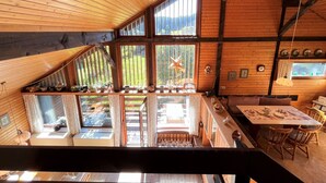 A cabin with a sloped ceiling, large windows, a dining area, and a view of the outdoors. - Beautiful private villa for 6 people with WIFI, TV, balcony and pets allowed (Außertal)