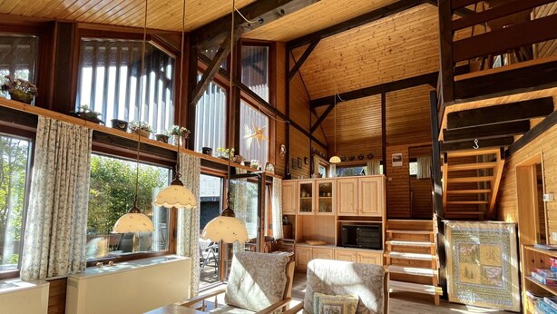 A cozy cabin interior with a dining area, wooden furniture, and large windows. - Beautiful private villa for 6 people with WIFI, TV, balcony and pets allowed (Außertal)