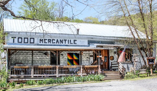 Um edifício rústico com uma placa indicando "TODD MERCANTILE" e uma placa com a palavra "PADARIA".