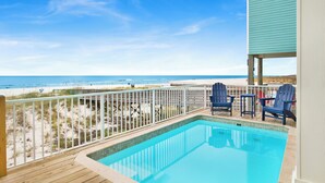 A pool area with a view of the beach, deck chairs, and a wooden deck. - Beachfront Luxury | Private Pool | Elevator (Gulf Shores)