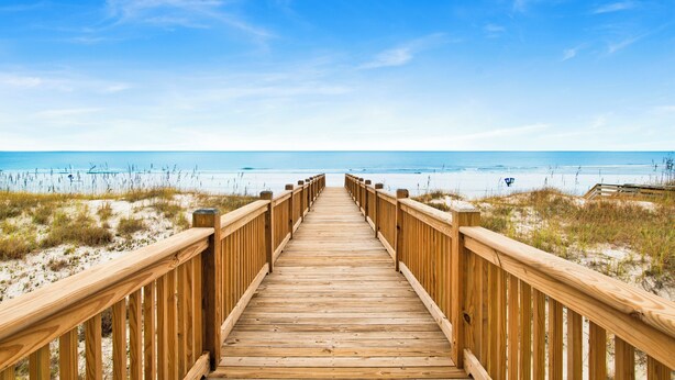 A wooden boardwalk leading to a beach with clear skies. - Beachfront Luxury | Private Pool | Elevator (Gulf Shores)