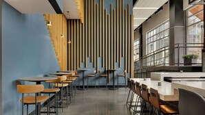 A modern interior with a bar area, seating, and a decorative wall with vertical elements.