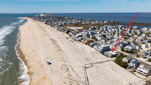 An aerial view of a coastal residential area with houses, a beach, and a pier. - 2026 AVAILABLE!PET FRIENDLY 1BR condo OCEANFRONT Building perfect for a COUPLE!! (Long Beach Township)