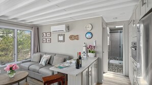 A modern kitchen with a built-in refrigerator, a dining area with a round table, and a shower room with a glass door. - 2026 AVAILABLE!PET FRIENDLY 1BR condo OCEANFRONT Building perfect for a COUPLE!! (Long Beach Township)