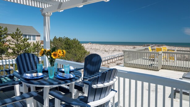 A covered outdoor seating area with a view of the beach and ocean. - 2026 AVAILABLE!PET FRIENDLY 1BR condo OCEANFRONT Building perfect for a COUPLE!! (Long Beach Township)