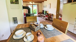 Un comedor acogedor con una mesa de madera preparada para dos, una cesta de pan y una vela.